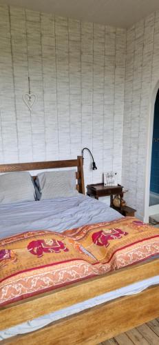 une chambre avec un grand lit avec une tête de lit en bois dans l'établissement Loft Bellevue, à Trôo