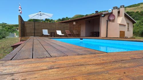 a wooden deck next to a swimming pool at Villa Marci con piscina privata a Nulvi (SS) in Nulvi