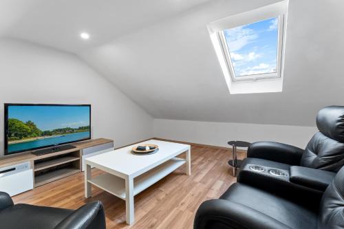 a living room with two chairs and a tv at Niewoh Ferienhaus Wiesenblick,Ammerland, Conneforde in Wiefelstede