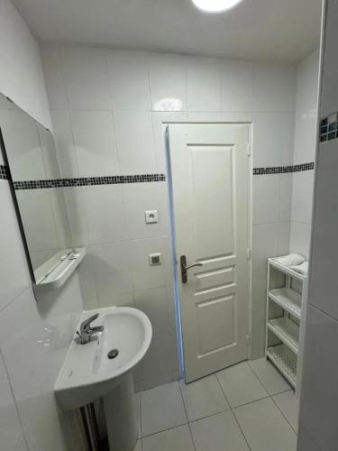 une salle de bain blanche avec un lavabo et un miroir dans l'établissement Appartement moderne à Villiers-le-Bel 35 m² accès Wifi gratuit, à Villiers-le-Bel