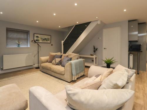 a living room with two couches and a staircase at The bungalow at 46 Church St in Chorley