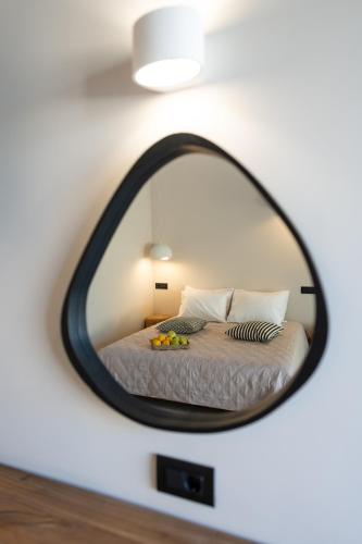 a mirror reflecting a bed in a bedroom at Afesou Suites in Ialyssos