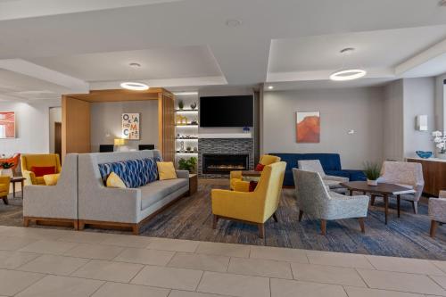 a living room with couches and chairs and a fireplace at Holiday Inn Express & Suites Oklahoma City NW - Quail Springs by IHG in Oklahoma City