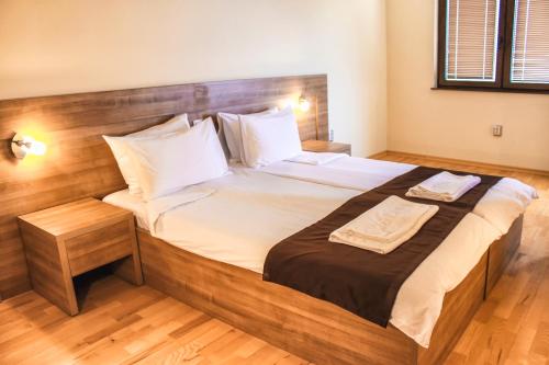 a bedroom with a large bed with a wooden headboard at Park Lakeside Ohrid in Ohrid