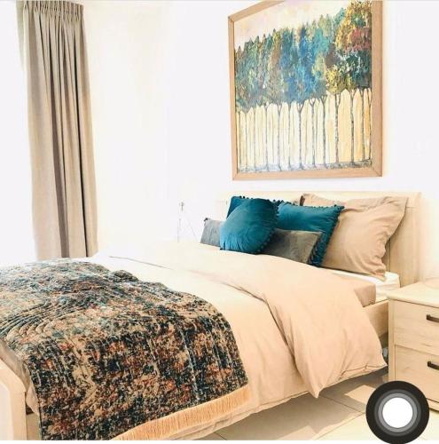 a bedroom with a bed and a painting on the wall at Embassy Gardens Royal Suites Apartments in Accra