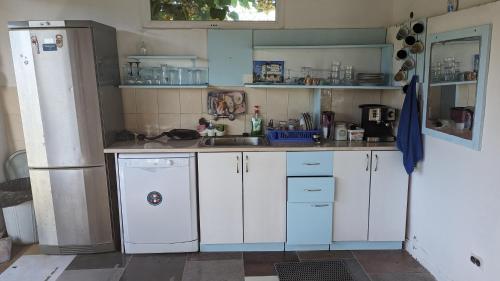 a kitchen with white cabinets and a sink at Guest House Chalakov in Sinemorets