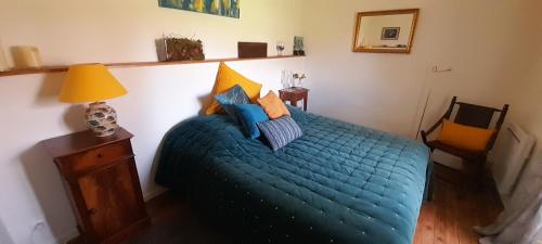 a bedroom with a blue bed with pillows on it at B&B La Vandelière Chambres chez l'Habitant in Macé