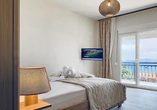a bedroom with a bed and a large window at Thalassa Beach Kavala in Paleo Tsifliki
