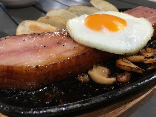 a plate of food with an egg on top of meat at Ma-Blue Garden House in Motobu