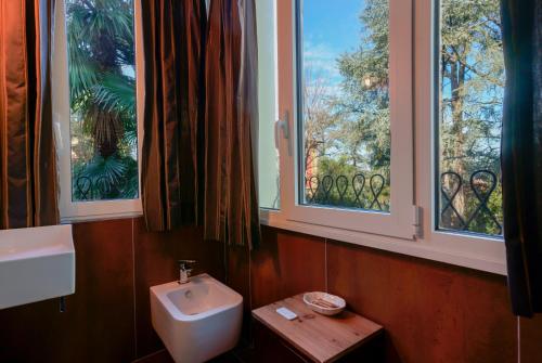 baño con lavabo y aseo y 2 ventanas en Ai tre cedri B&B, en Bolonia