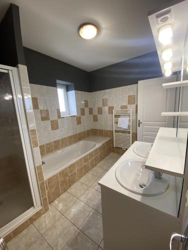 a bathroom with a tub and a sink and a bath tub at Domaine de la RIMBERTIÈRE in Thuré
