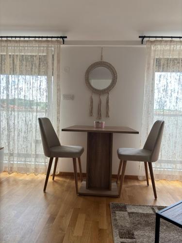 a dining room table with two chairs and a mirror at KIA APARTMENT 2 in Valjevo