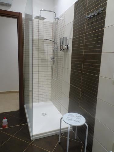 een douche met een kruk naast een glazen deur bij A casa di Pako in Salerno