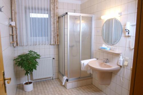 uma casa de banho com um chuveiro e um lavatório. em Röhrs Gasthof em Sottrum