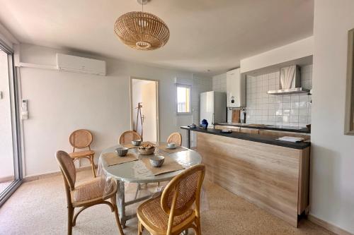 une cuisine et une salle à manger avec une table et des chaises dans l'établissement L'ANCRE MARINE - Appartement 2 chambres avec parking proche de la plage, au Grau-du-Roi
