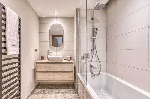 La salle de bains est pourvue d'une baignoire, d'un lavabo et d'une douche. dans l'établissement Kristal, à Megève