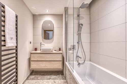 une salle de bain avec une baignoire, un lavabo et une douche dans l'établissement Kristal, à Megève