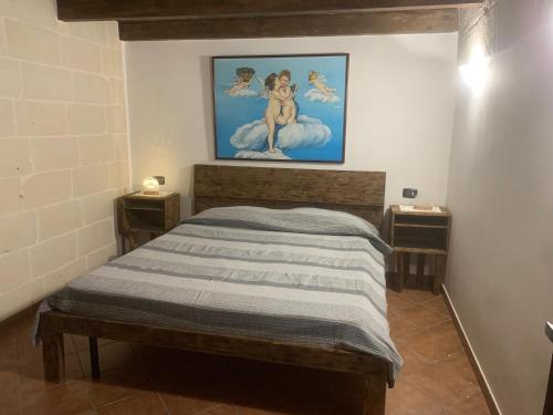 Schlafzimmer mit einem Bett mit Wandgemälde in der Unterkunft Xenia renting in Massafra