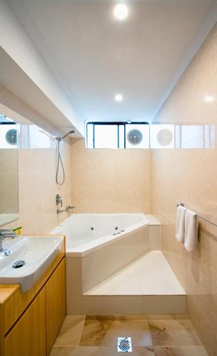 a large bathroom with a tub and a sink at Mahoneys Motor Inn in Melbourne