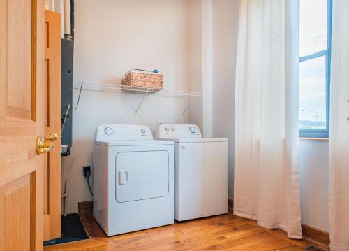 a laundry room with a washer and dryer next to a window at River City Loft in Portsmouth