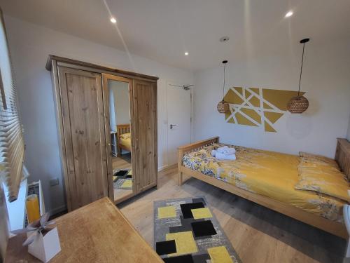1 dormitorio con cama y espejo en Mini hotel with home facilities in Hamilton West, en High Blantyre