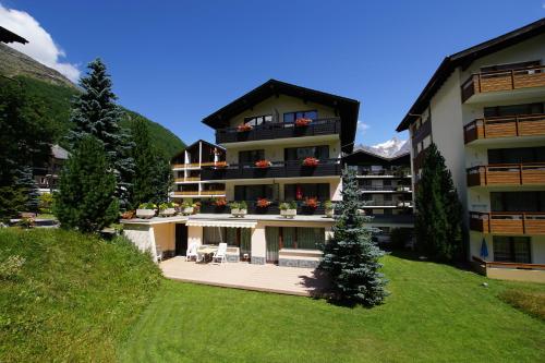 a large building with a lawn in front of it at Haus Aida in Saas-Fee
