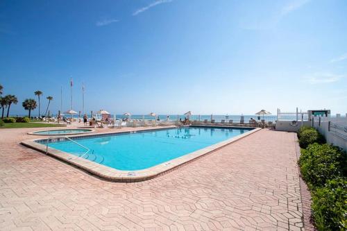 una piscina con vista sull'oceano sullo sfondo di SeaBliss, oceanfront 1st floor cozy condo a Daytona Beach