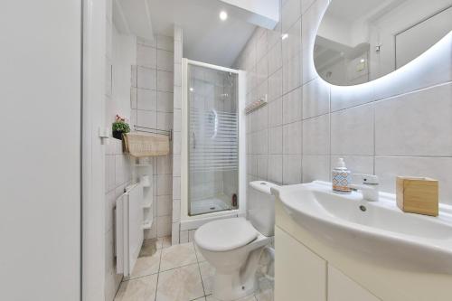 une salle de bain blanche avec des toilettes et un lavabo dans l'établissement Arkade - gaming room proche gare - jeux, à Mulhouse