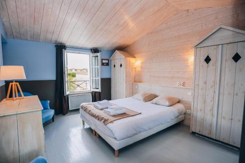 een slaapkamer met een groot bed en een raam bij Villa Cote Ouest in La Flotte