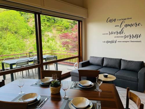 a dining room with a table and a couch at Residenz La Selva in Ghiffa