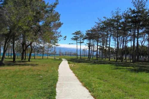 un camino a través de un parque con árboles y un campo en Ivago Apartments, en Privlaka