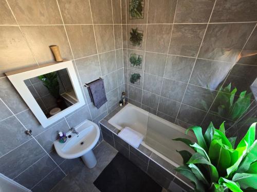 a bathroom with a sink and a toilet and a tub at Casa-Pel Guest Wing in Palatswe