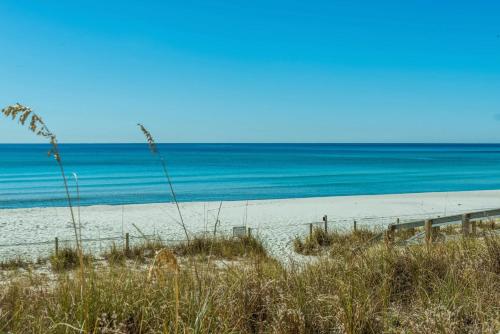 a sandy beach with the ocean in the background at Ocean Reef 904 by Emerald Coast Retreats in Panama City Beach