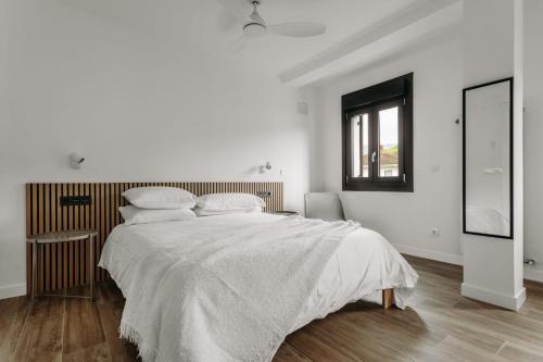 een witte slaapkamer met een groot bed en een raam bij Apartamento turístico Legate in Elizondo