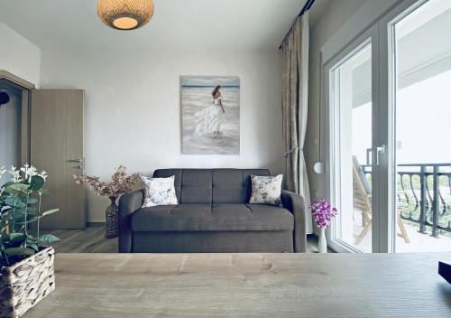 a living room with a couch and a window at Thalassa Beach Kavala in Paleo Tsifliki