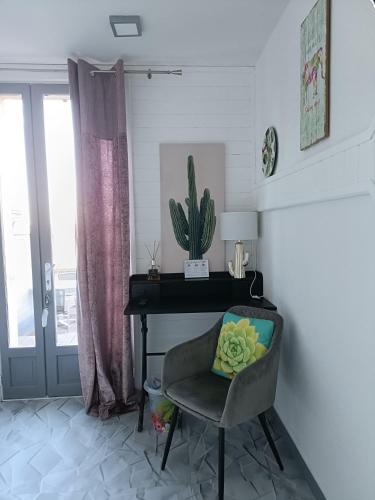 a chair in a room with a piano and a cactus at Hôtel Bien-Être Aux Cyprès de Marquay in Marquay
