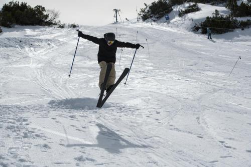 a person on skis jumping in the snow at Gjaid-Alm 1739m am Dachstein-Only Accessible by Cable Car in Obertraun