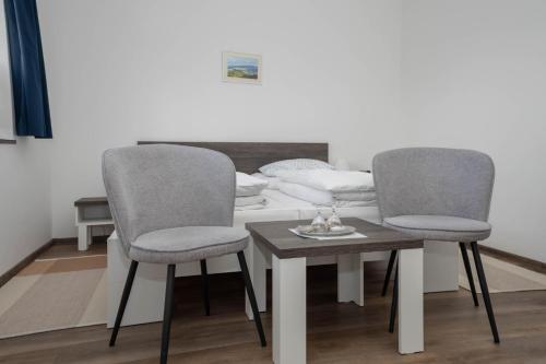 2 sillas y una mesa en una habitación en Penzion u Hanky en Telgárt