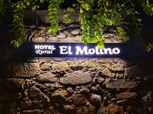 a blue street sign on a brick wall at Hotel Rural El Molino in Baños de Montemayor