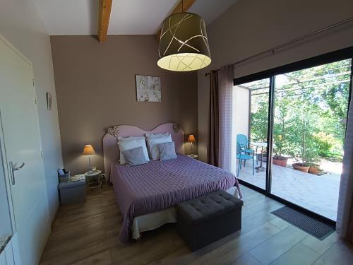 1 dormitorio con cama morada y ventana grande en Mas Auroma en Murs