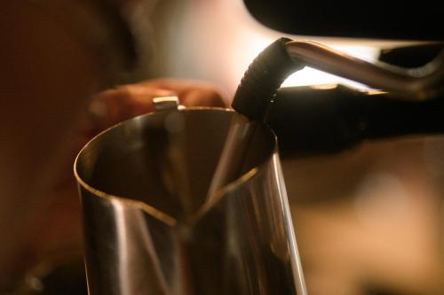 a person is pouring liquid into a metal cup at Gjaid-Alm 1739m am Dachstein-Only Accessible by Cable Car in Obertraun