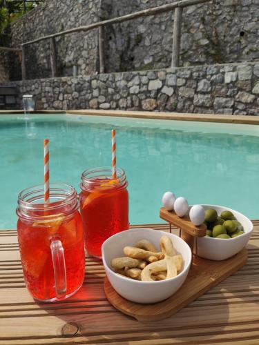 uma bandeja de comida e bebidas junto a uma piscina em Monte Brusara Relais em Ravello