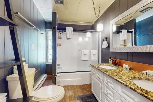 a bathroom with a sink and a toilet and a shower at The Purple Beach House in Bremerton