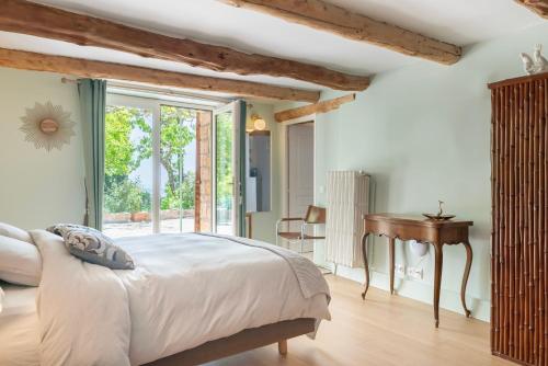 a bedroom with a bed and a desk and a window at Domaine des Encourdoules in Vallauris