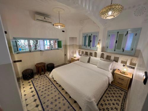 1 dormitorio con 1 cama blanca y 2 ventanas en Maison d'hôtes Dar Farhana en Ouarzazate