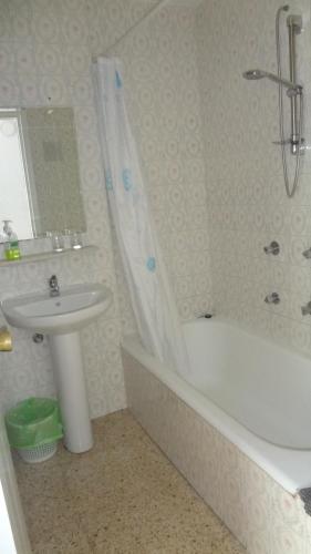 托雷莫利諾斯的住宿－Hotel Carlos I，浴室配有盥洗盆、浴缸和盥洗盆