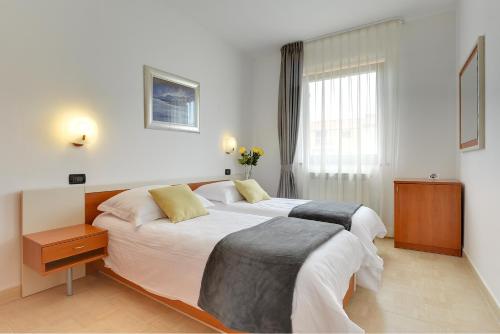 羅維尼的住宿－Villa NiNa B&B Rovinj，酒店客房设有两张床和窗户。