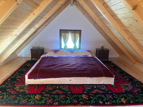a bedroom with a large bed in a attic at Vikendice Suvo Do in Berane