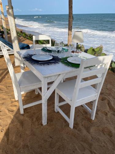 a white table and chairs on the beach at La Maison Bleue Lome in Lomé