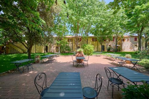 een groep tafels en stoelen op een binnenplaats bij Agriturismo Il Piaggione in Campiglia Marittima